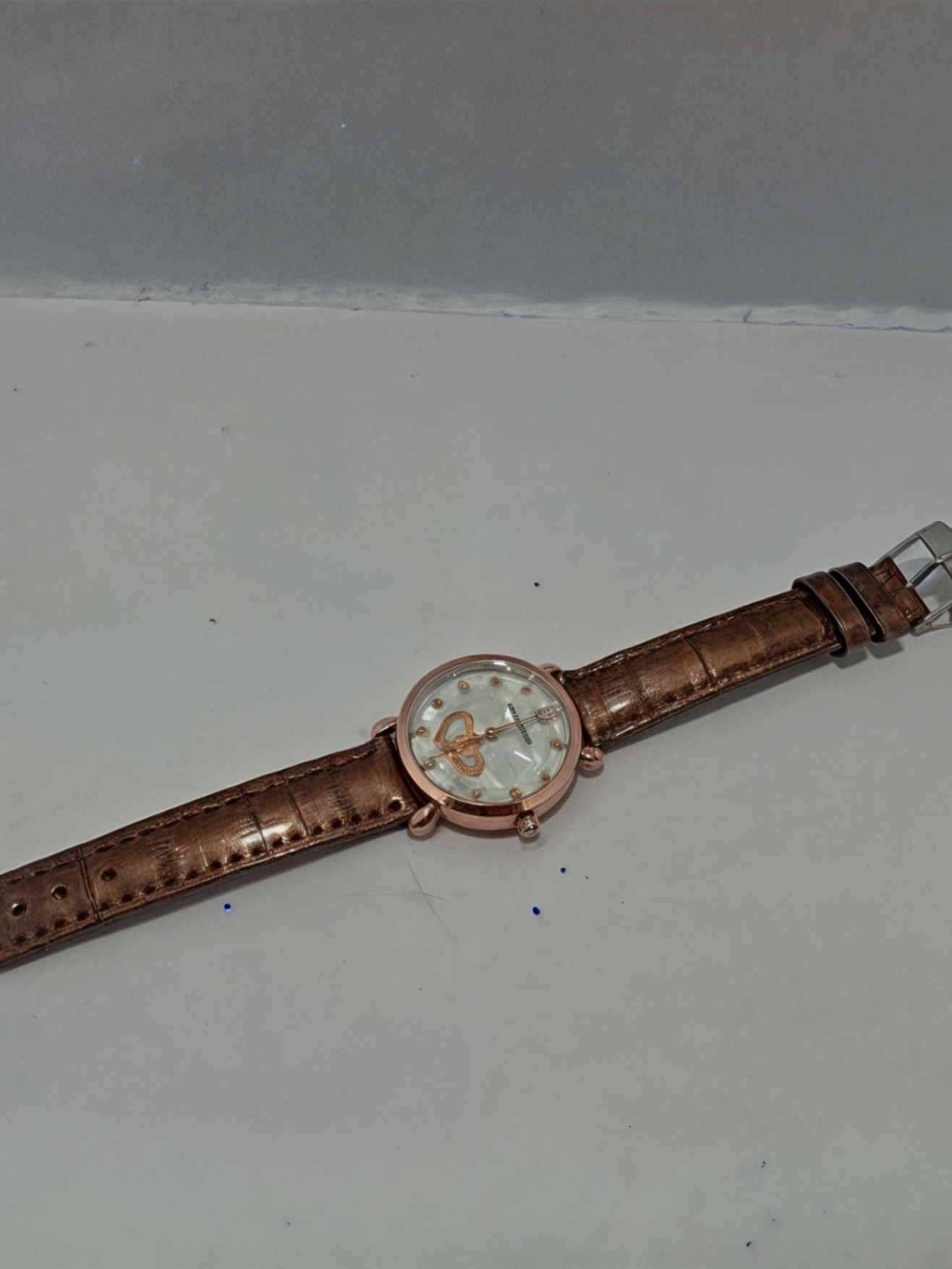 brown watch on white surface