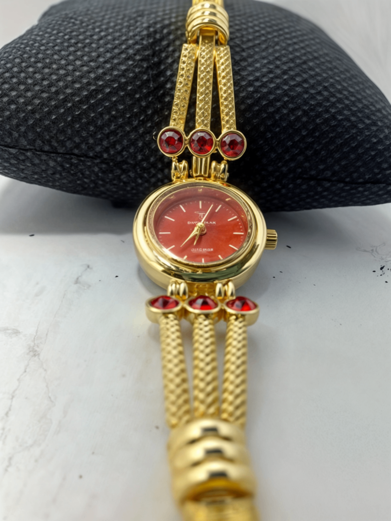 red face golden watch on pillow