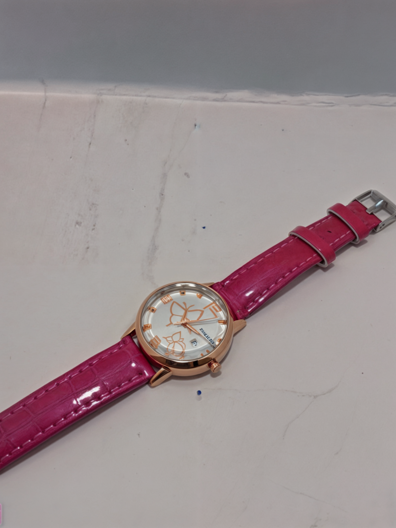 pink watch for girls on white surface